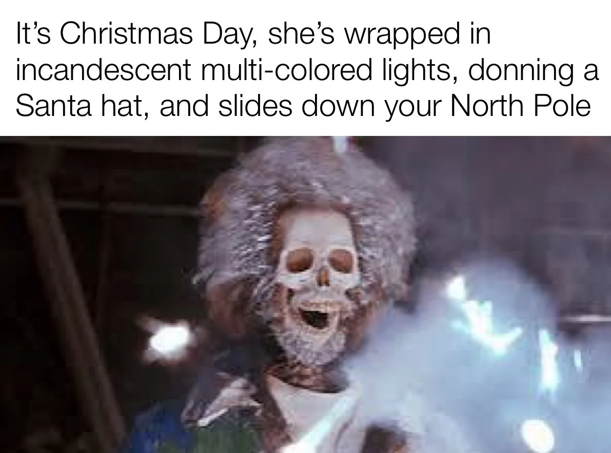 A person with a skull face and a large, fluffy afro wig is shown in a blurry, dark setting with bright, out-of-focus lights…