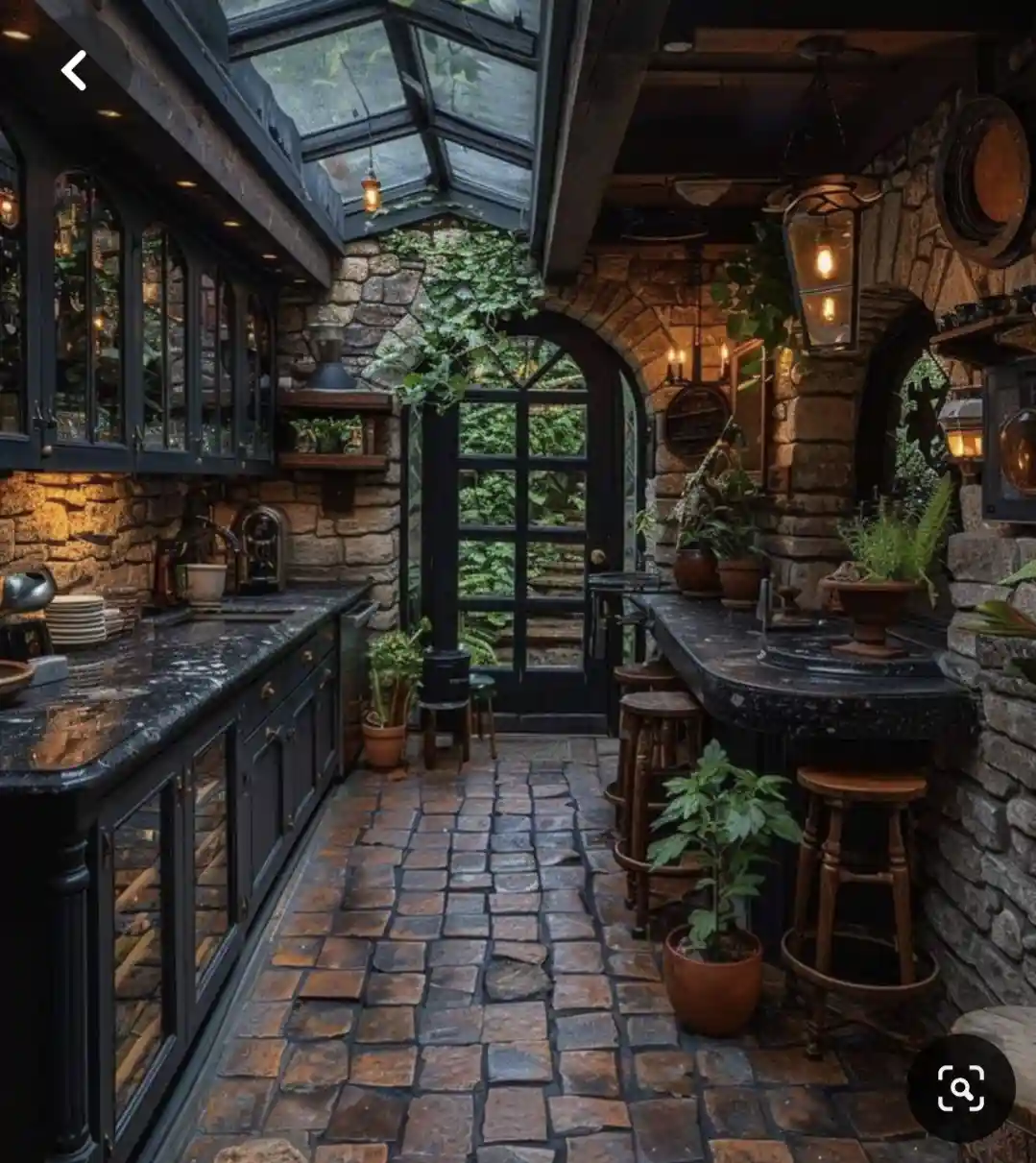 A luxurious, rustic kitchen with stone walls, dark wood cabinetry, and a glass roof, featuring potted plants, bar stools…