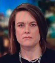 A woman with shoulder-length brown hair and a silver necklace stares directly at the camera with a deadpan, unimpressed…