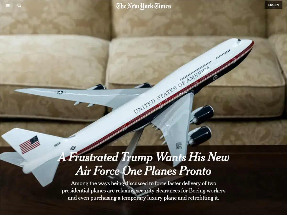 A model of Air Force One sits on a stand on a wooden table in front of a beige couch, with overlaid text mimicking a New…