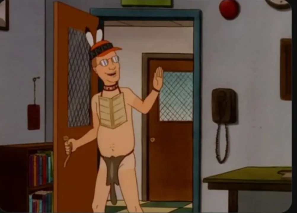 a cartoon man in a doorway wearing a feathered hat, glasses, a choker, and a loincloth, holding a club and waving. The…