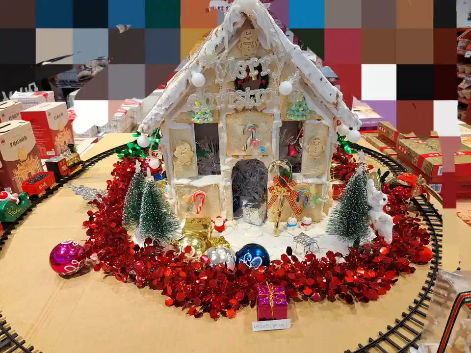 A festive gingerbread house decorated with white icing, candy canes, and gingerbread men, surrounded by red tinsel…