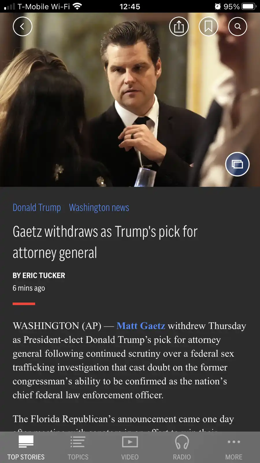A screenshot of a news article on a mobile app shows a photo of Matt Gaetz in a suit looking serious while holding a glass…
