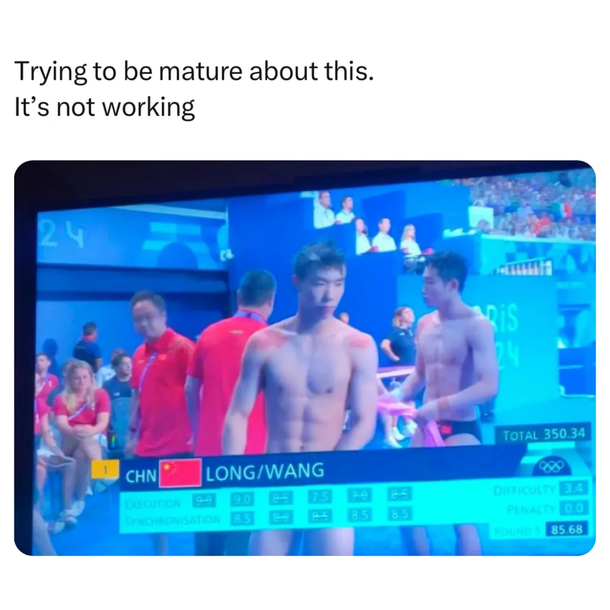 Two shirtless male divers from China, Long and Wang, stand on a diving platform after a competition, looking visibly…