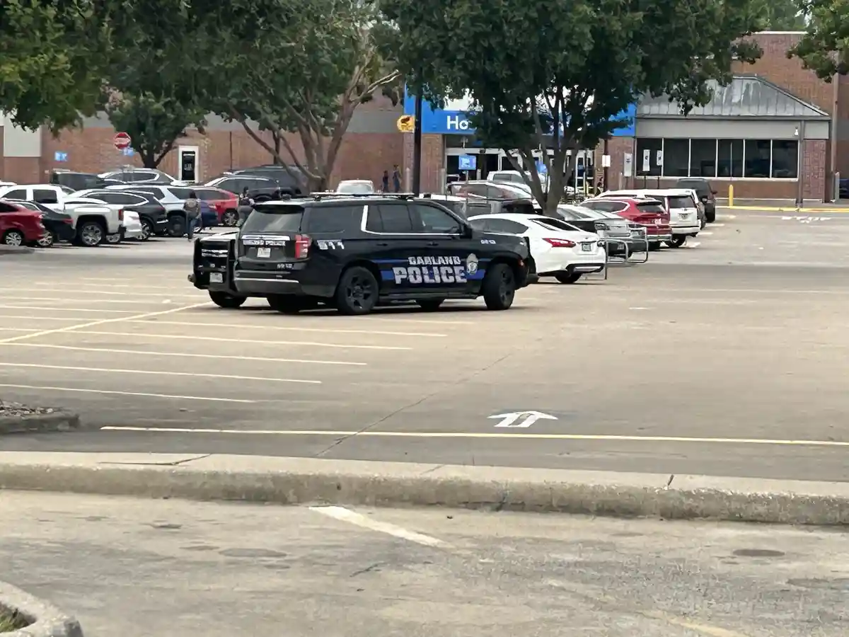 A black Garland Police SUV is parked diagonally in a commercial parking lot, occupying multiple spaces. The vehicle is…