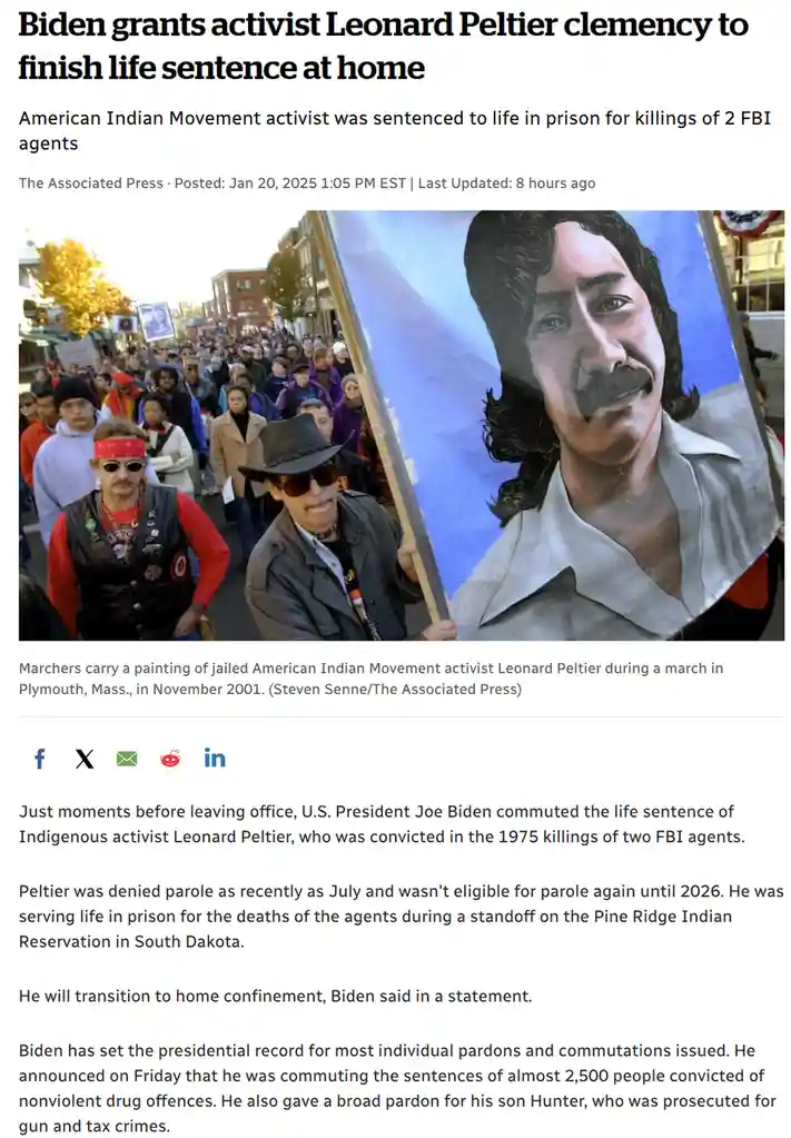 A screenshot of a news article shows a photo of protesters carrying a large portrait of Leonard Peltier during a 2001 march…