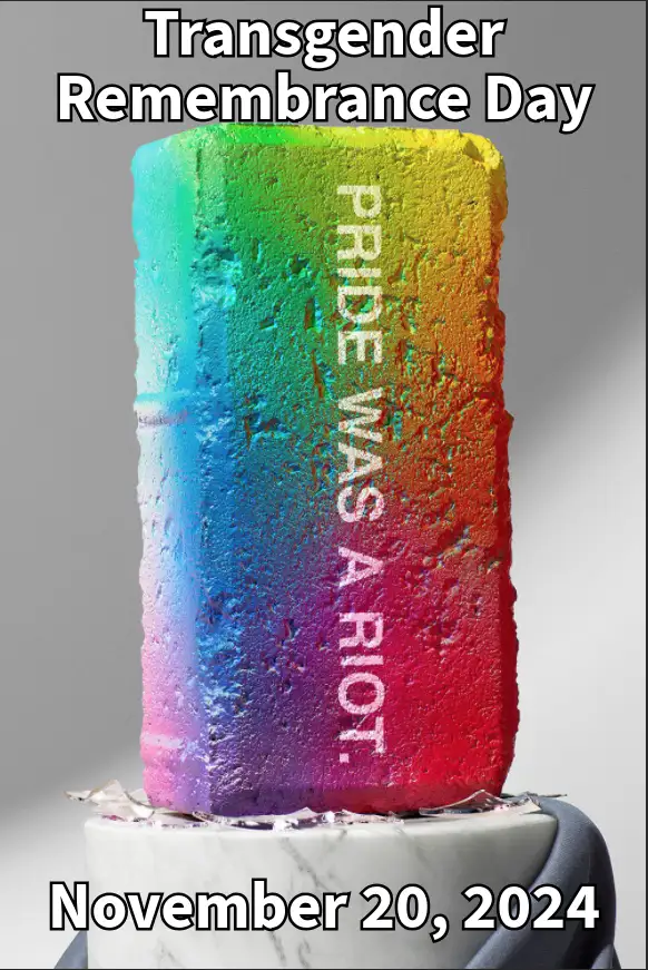 A rainbow-colored brick, textured like wet concrete, sits on a marble pedestal with a dark blue cloth draped over its base…