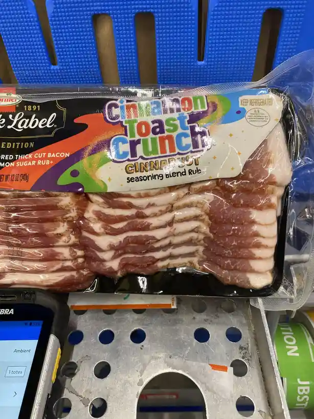 A package of bacon is visibly labeled with 'Cinnamon Toast Crunch CINNADUST seasoning blend Rub', creating a humorous…