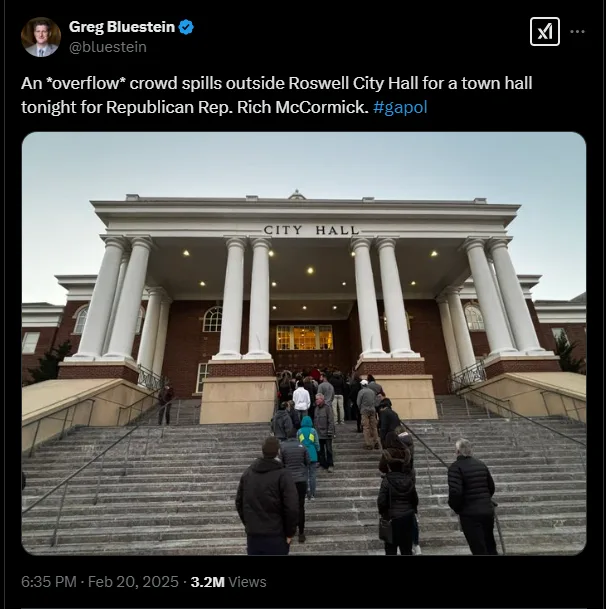 A screenshot of a tweet by Greg Bluestein showing a crowd of people spilling out from the steps of Roswell City Hall, which…
