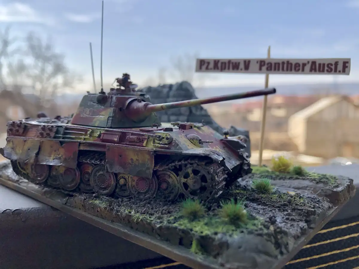 A highly detailed, weathered model of a German Panther tank (Pz.Kpfw.V 'Panther'Ausf.F) sits on a diorama base with mud…
