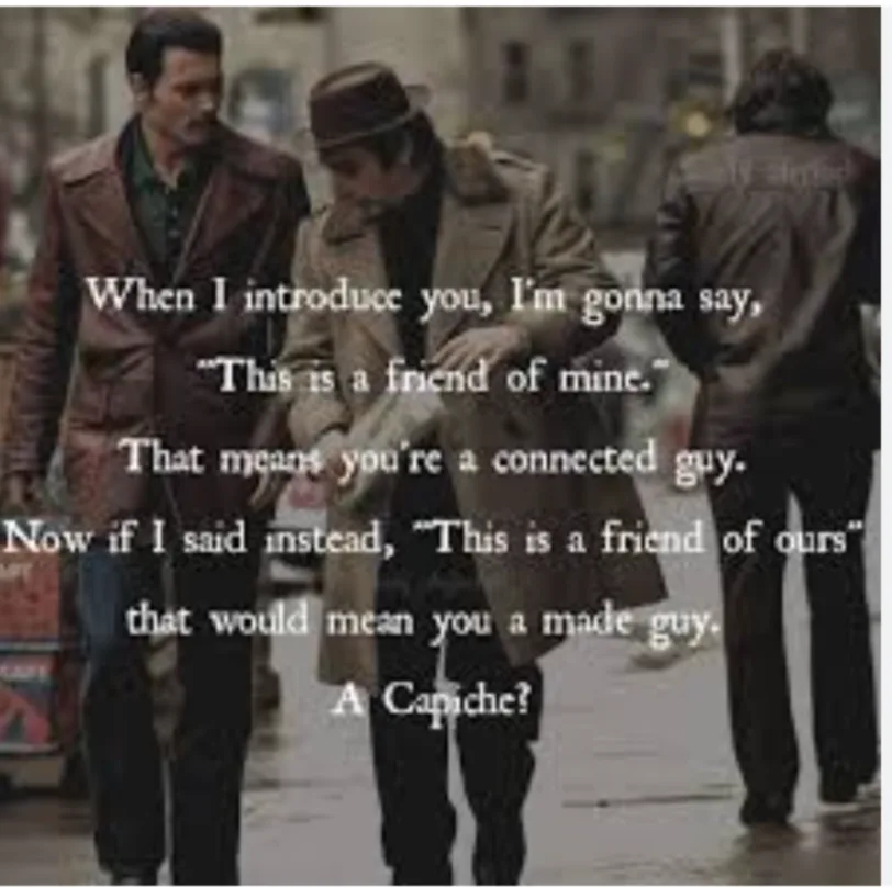 Two men in trench coats and hats walk down a city street, overlaid with text explaining the difference between being 'a…