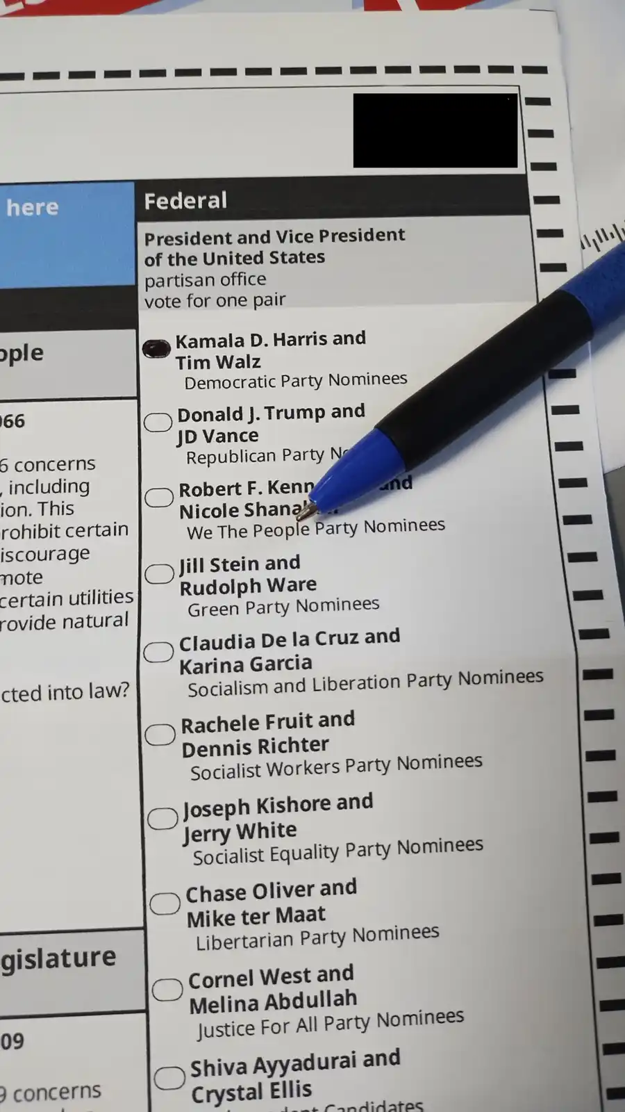 A close-up photo of a U.S. federal ballot showing the presidential race, with a blue pen resting on the ballot next to the…