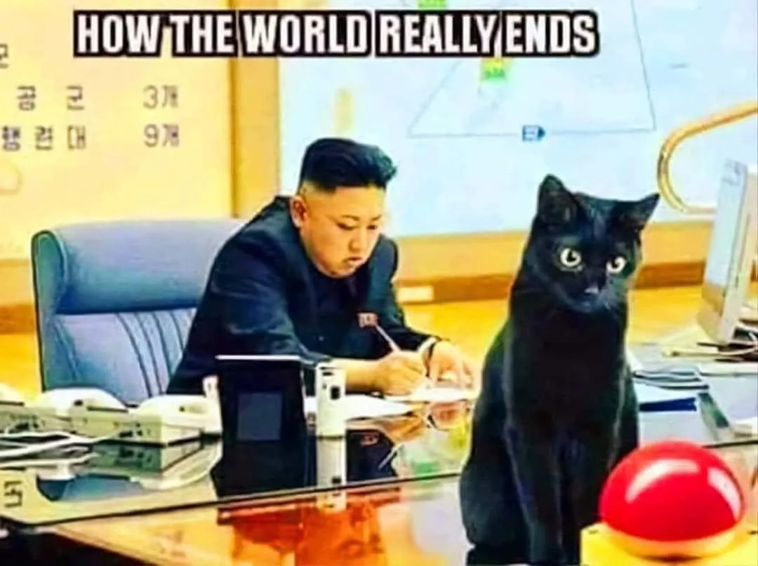 A man in a dark suit sits at a desk writing, beside him a black cat stares intently at the camera. The image has bold white…