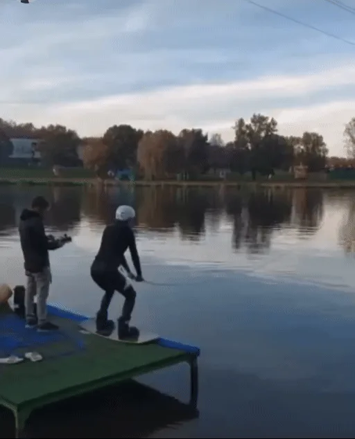 A six-panel sequence shows a person in a wetsuit and helmet preparing to water ski from a dock, then launching into the…
