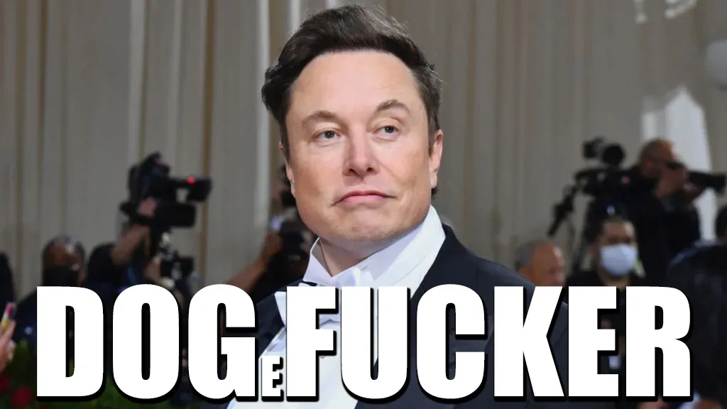 A close-up photo of Elon Musk wearing a black tuxedo and white shirt, looking slightly annoyed or unimpressed. Behind him…