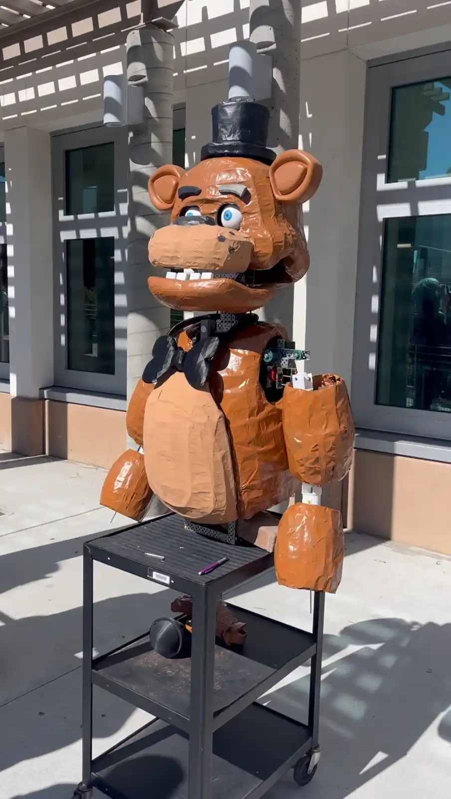 A large, orange, papier-mâché animatronic bear resembling Freddy Fazbear from the 'Five Nights at Freddy's' video game…