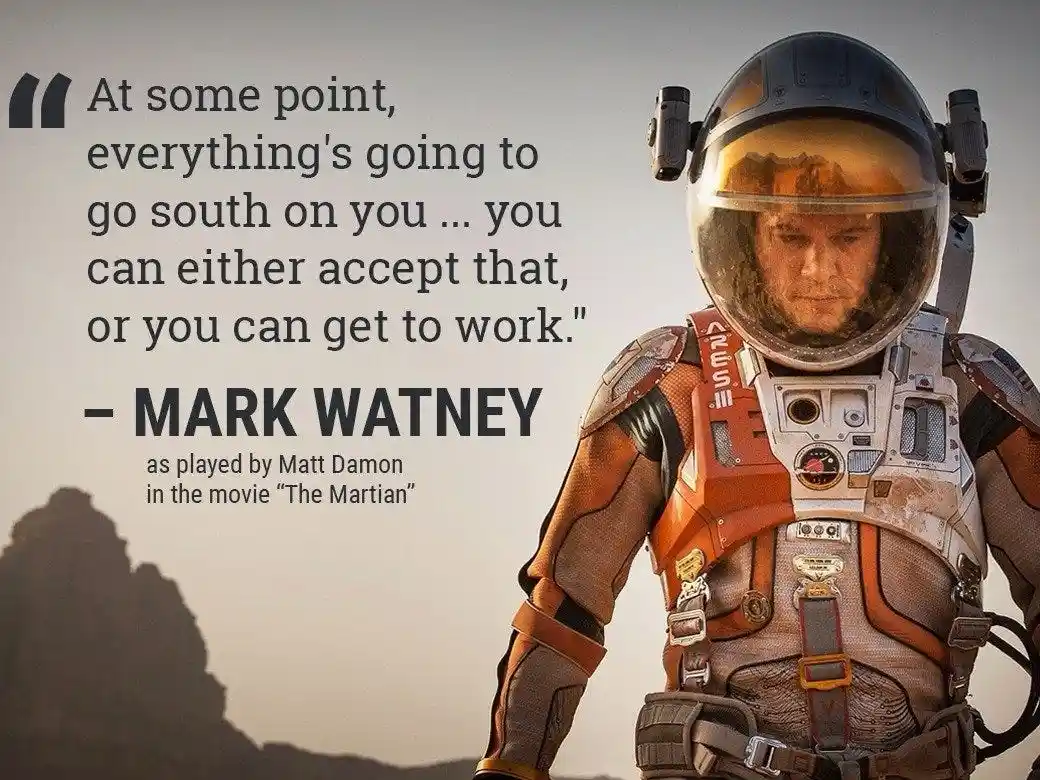 An astronaut in an orange and grey spacesuit with a reflective helmet stands against a hazy, rocky Martian landscape…