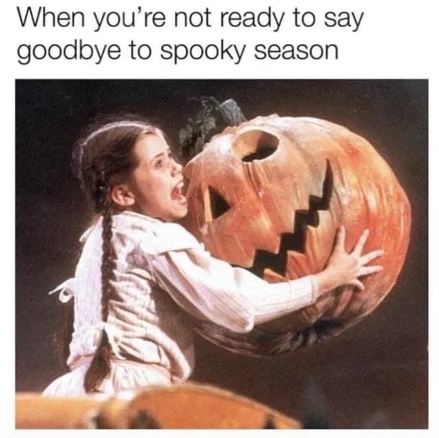 A young girl in a white dress with braided hair is shown hugging a large, carved jack-o'-lantern with a jagged grin, her…
