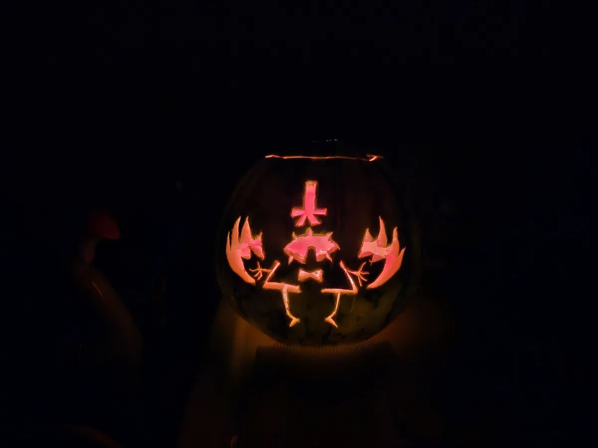 A carved pumpkin illuminated from within in a dark setting, featuring a design resembling the character from the game…
