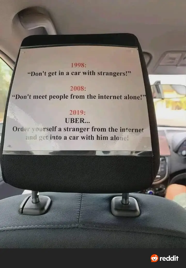 A printed note is taped to a car headrest, listing safety advice from 1998 to 2019. The 1998 warning is 'Don't get in a car…
