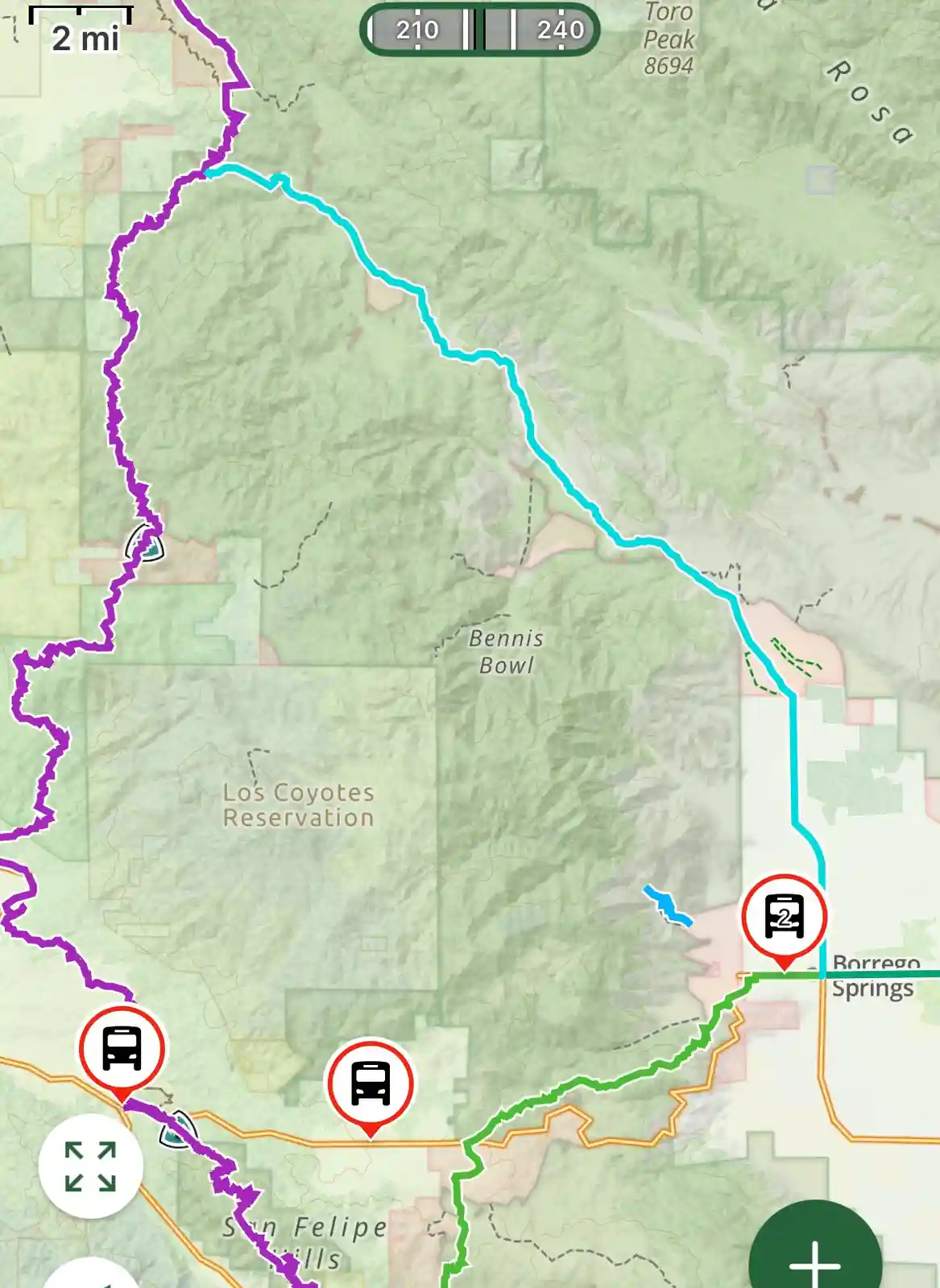 A hiking map shows a blue trail winding through mountains, with three bus stop icons marked along the route near Borrego…