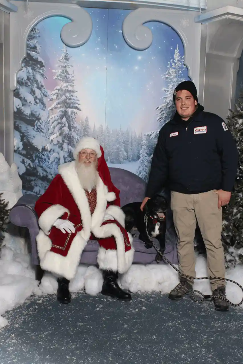 Three vertically stacked photos show a man in a dark uniform standing beside a seated Santa Claus in a snowy backdrop. In…