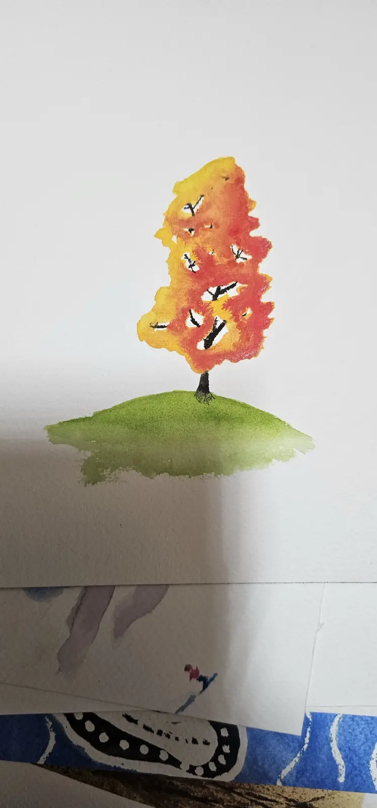 A watercolor painting of a tree with fiery orange and yellow leaves on a green hill, overlaid with the text 'i drew a tree…