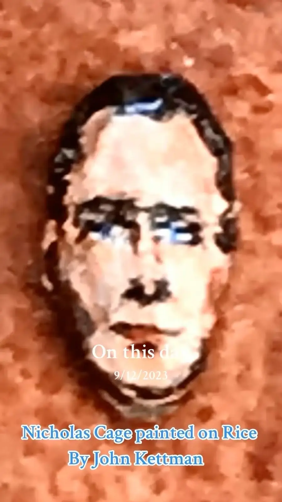 A heavily pixelated and low-resolution image shows a blurry portrait of a man with dark hair and glasses against a textured…