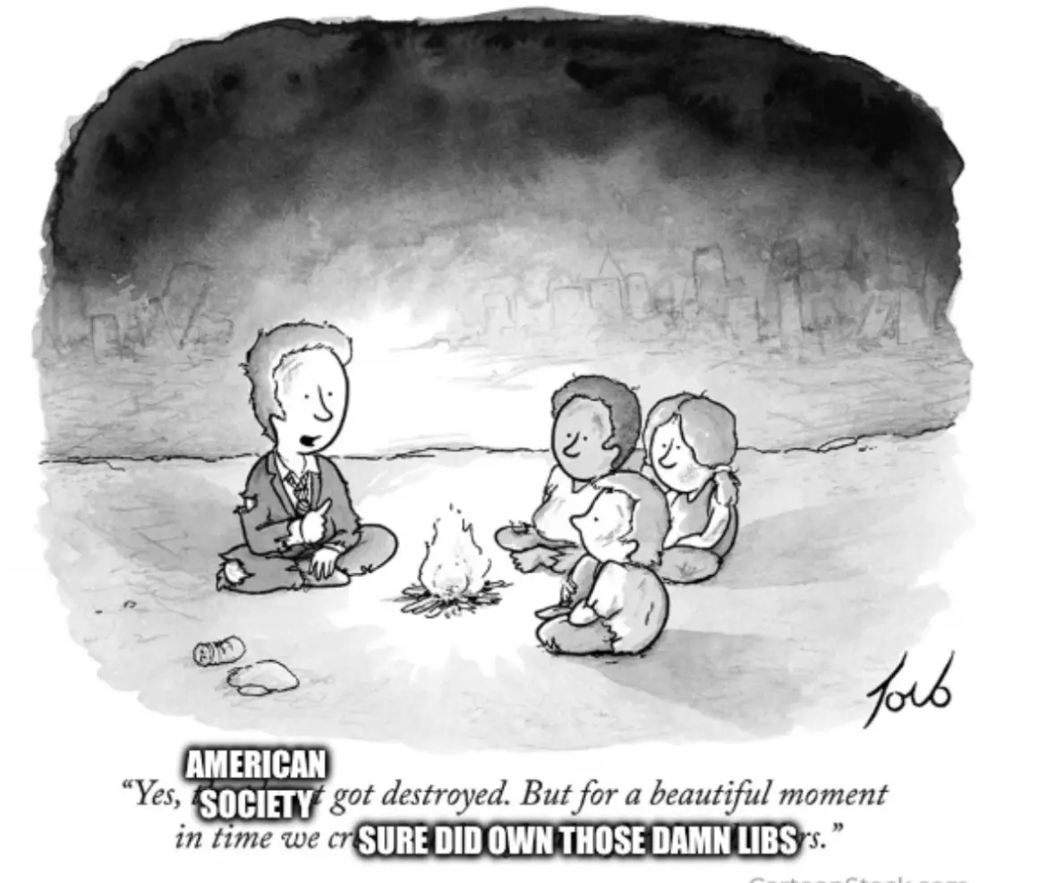 A black-and-white cartoon shows four people sitting around a campfire in a desolate, ruined landscape with a city skyline…