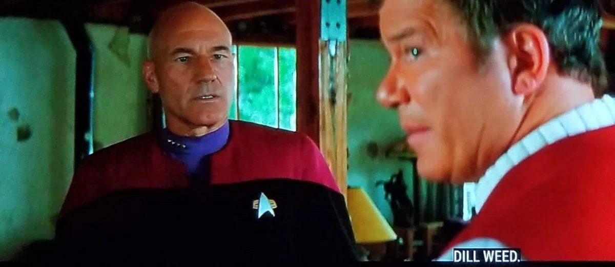A still from Star Trek: The Next Generation shows Captain Picard in a red uniform facing a crew member in a red uniform. The…