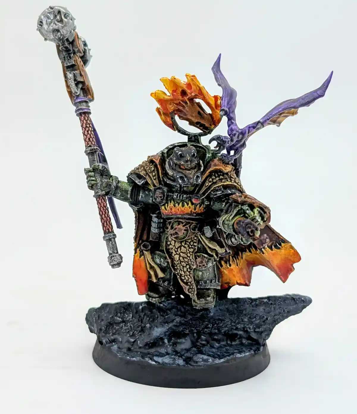 A heavily detailed, hand-painted miniature of a fantasy warrior with a grotesque, frog-like face, holding a large ornate…