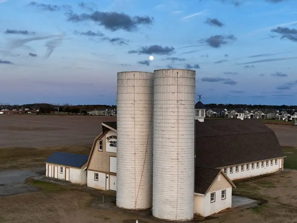 An aerial photo shows two large white silos next to a barn-like building with 'TOWNSEND BANK & TRUST' written on its side…