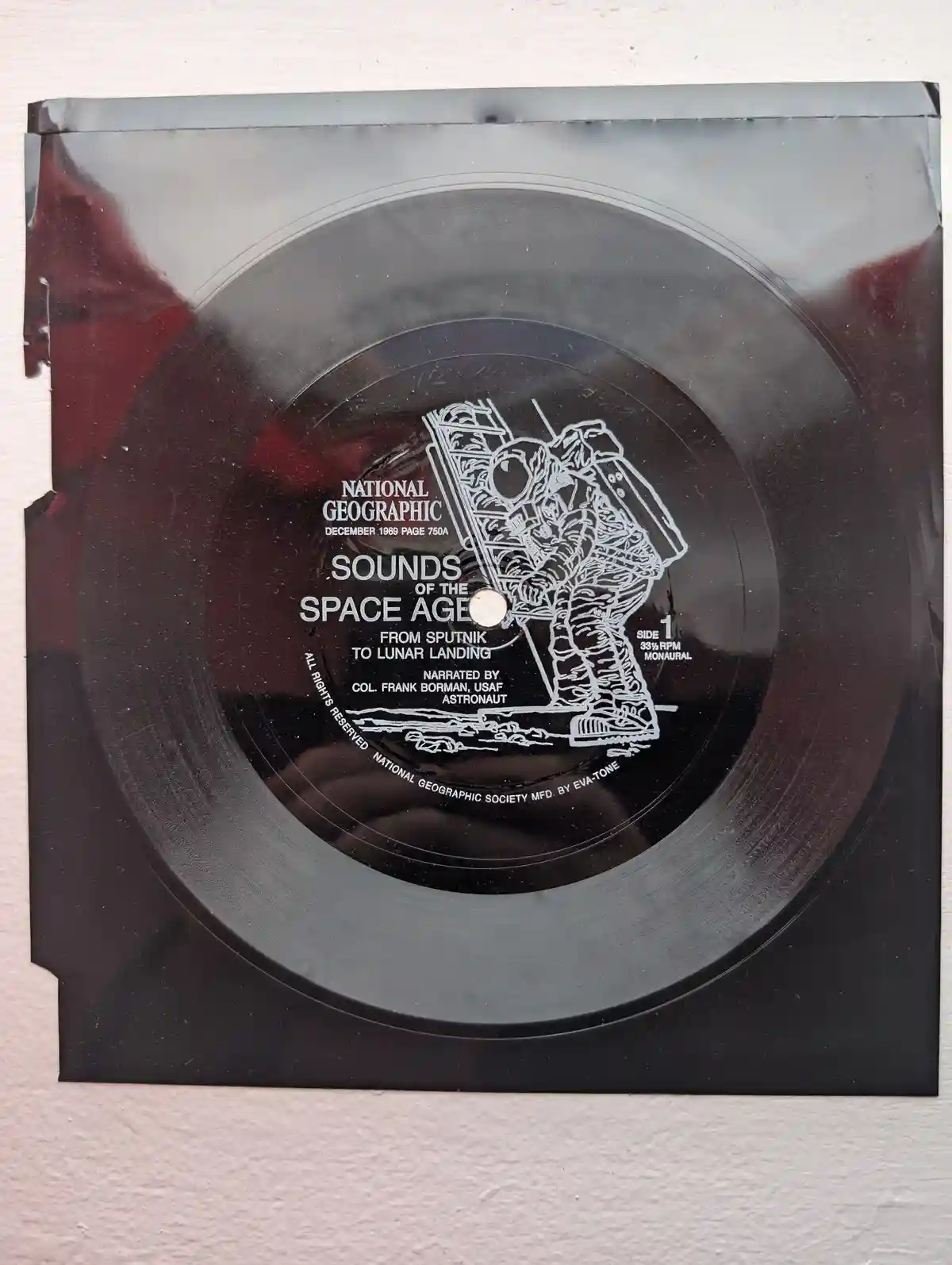 A black vinyl record with white text and illustration, labeled 'SOUNDS OF THE SPACE AGE FROM SPUTNIK TO LUNAR LANDING' and…