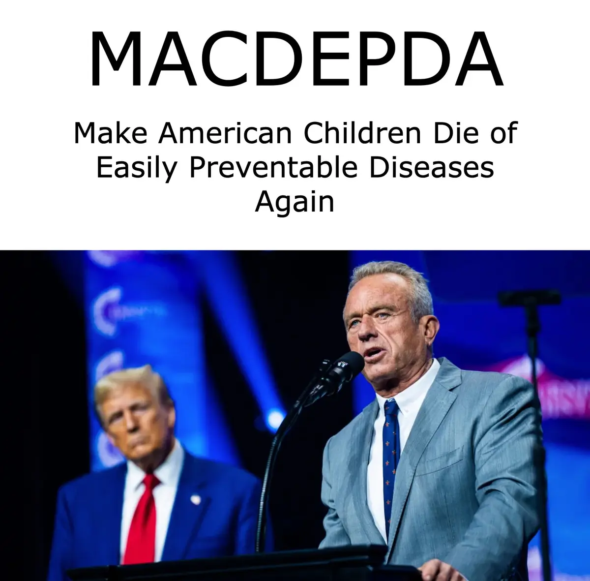 The image shows a man in a gray suit speaking at a podium with a microphone, while a blurred image of Donald Trump stands…
