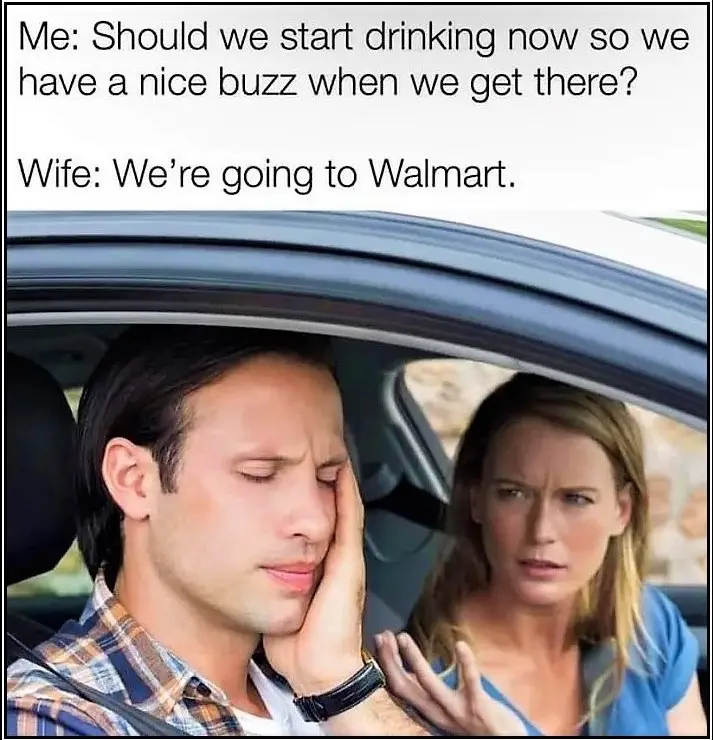 A man in a plaid shirt sits in a car, looking exhausted and rubbing his face, while a woman in a blue shirt looks at him…