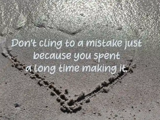 A heart shape drawn in wet sand on a beach, with sunlight reflecting off the water nearby. Overlaid white text reads: 'Don't…