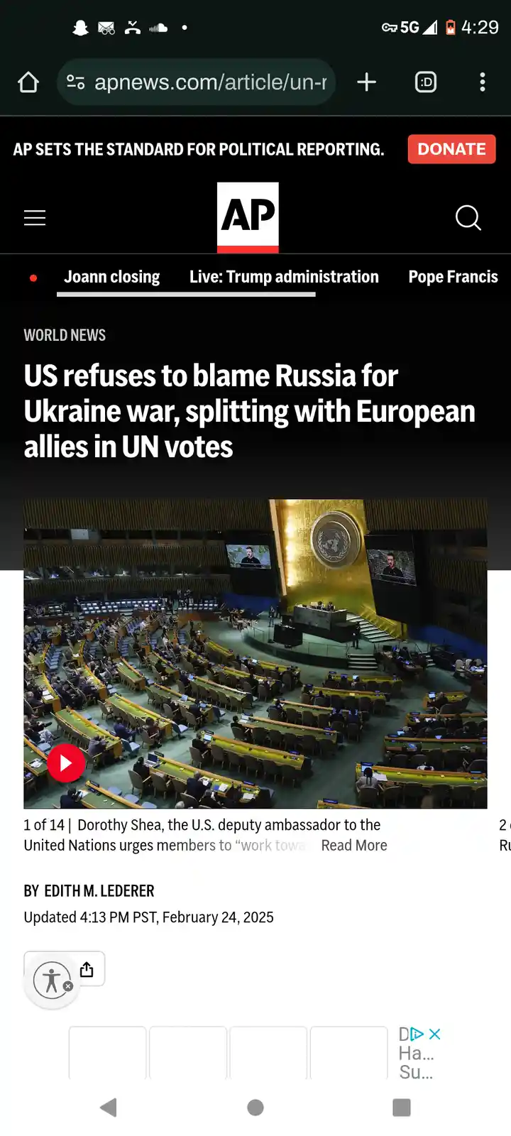 A screenshot of an AP News article headline about the US refusing to blame Russia for the Ukraine war, displayed over a…