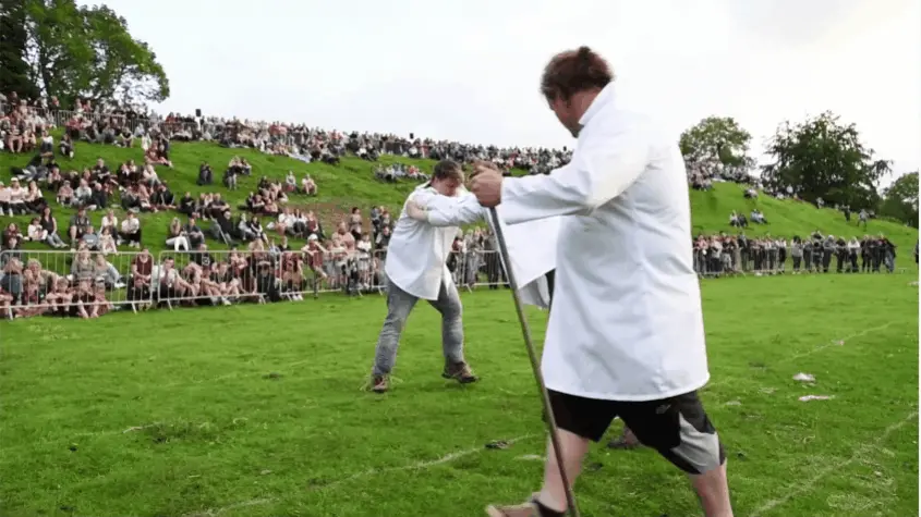 A sequence of six photos shows a man in a white lab coat using a long pole to push another man to the ground in front of a…