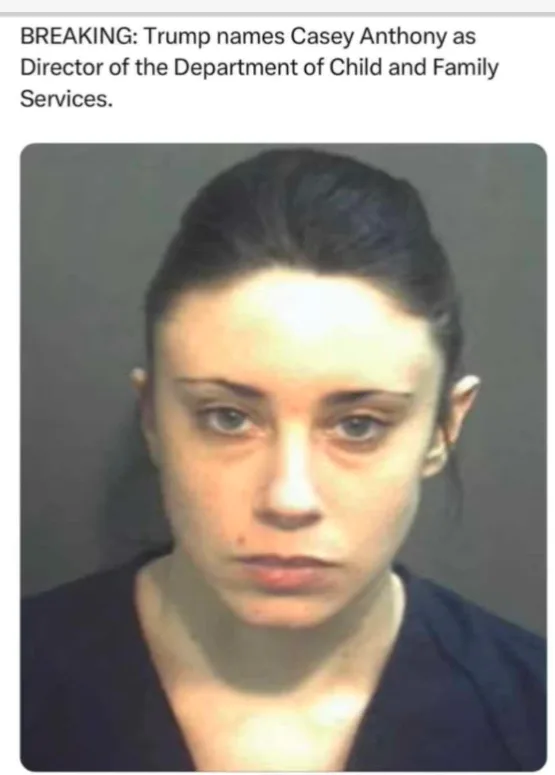 A mugshot of Casey Anthony, a woman with dark hair pulled back, wearing a dark blue top, looking directly at the camera with…