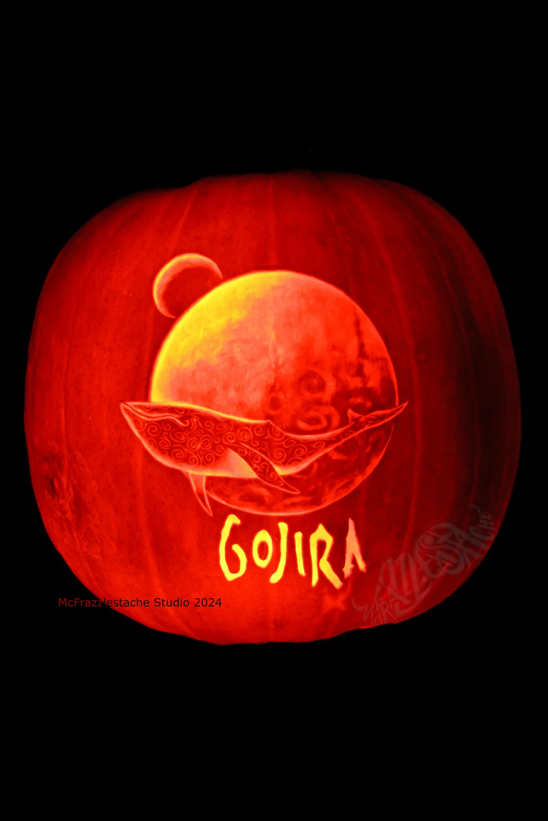 A carved pumpkin illuminated from within, featuring a detailed design of a whale swimming around a large sphere with a…