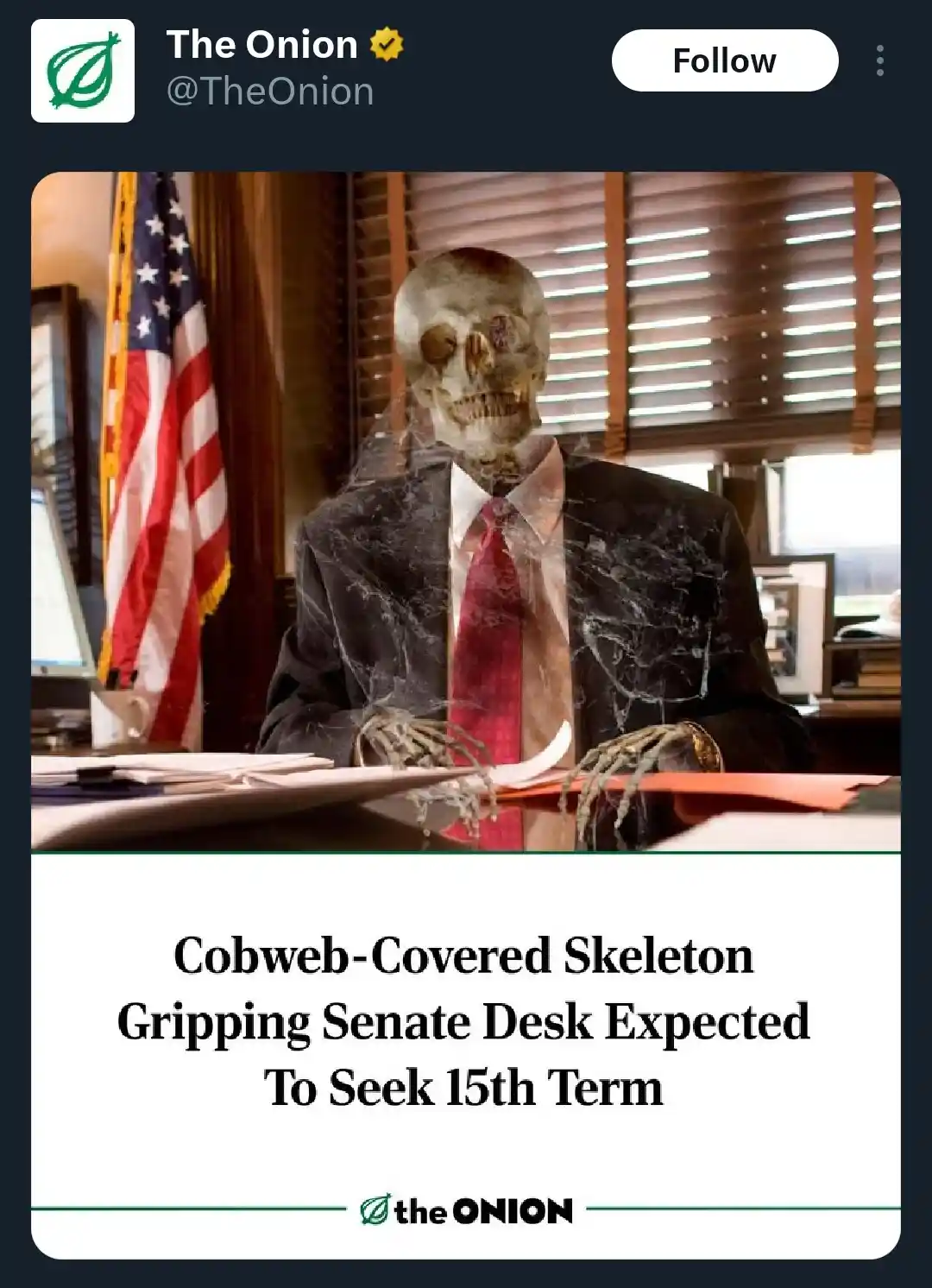 A skeleton wearing a suit and red tie sits at a desk in an office with an American flag, covered in cobwebs. The overlaid…