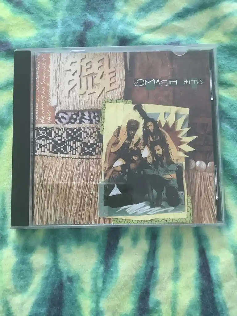 A CD case for a compilation album titled 'SMASH HITS' featuring a collage of images including four men with dreadlocks, a…