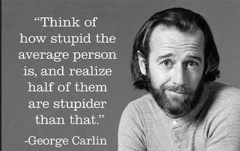 A black-and-white photo of George Carlin looking directly at the camera with a slightly skeptical expression. Overlaid text…