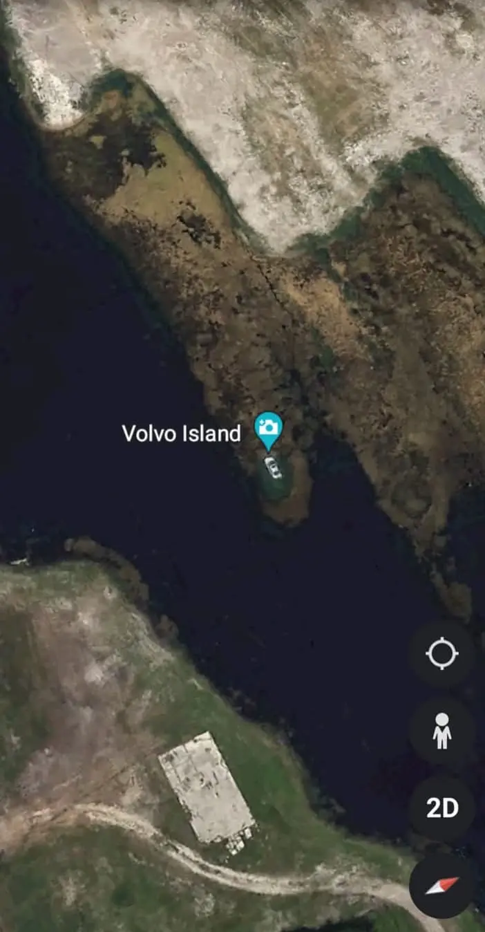 A satellite map view shows a small landmass labeled 'Volvo Island' with a blue location pin and a white car icon on it. The…