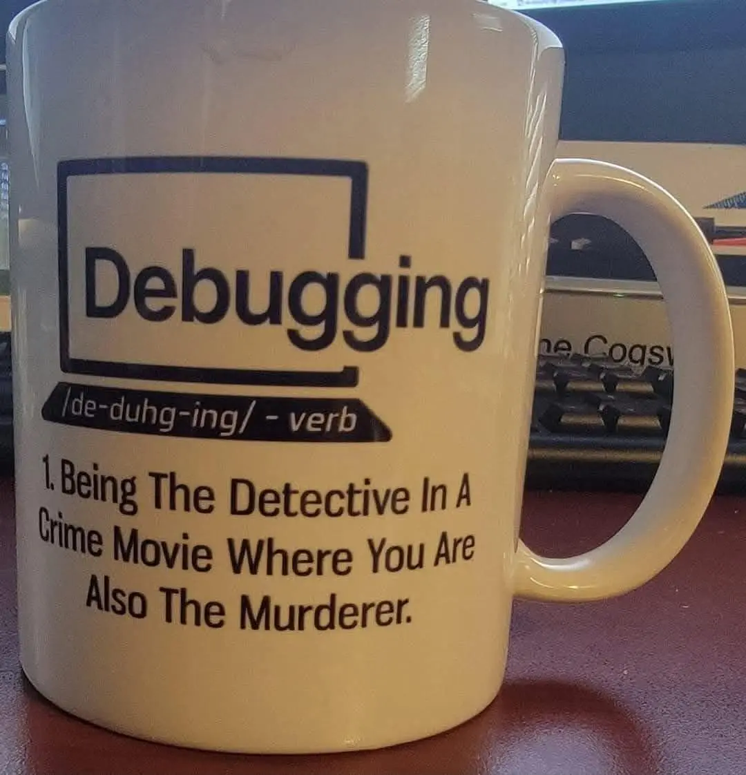 A white ceramic mug with black text defines 'Debugging' as a verb with a humorous definition: 'Being The Detective In A…
