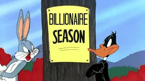 Bugs Bunny and Daffy Duck stand on either side of a wooden post with a yellow sign that reads 'BILLIONAIRE SEASON'. Bugs…