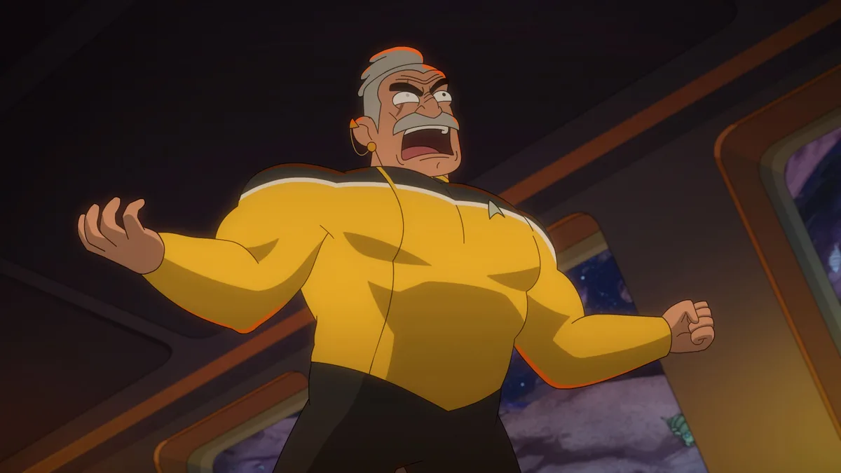 An animated muscular man in a yellow Starfleet uniform with a gray mustache and hair, standing in a spaceship corridor with…