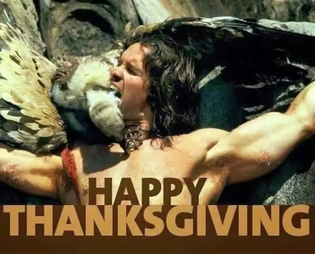 A shirtless, muscular man with dark hair is lying on his back, clutching a large bird with outstretched wings. The bird's…