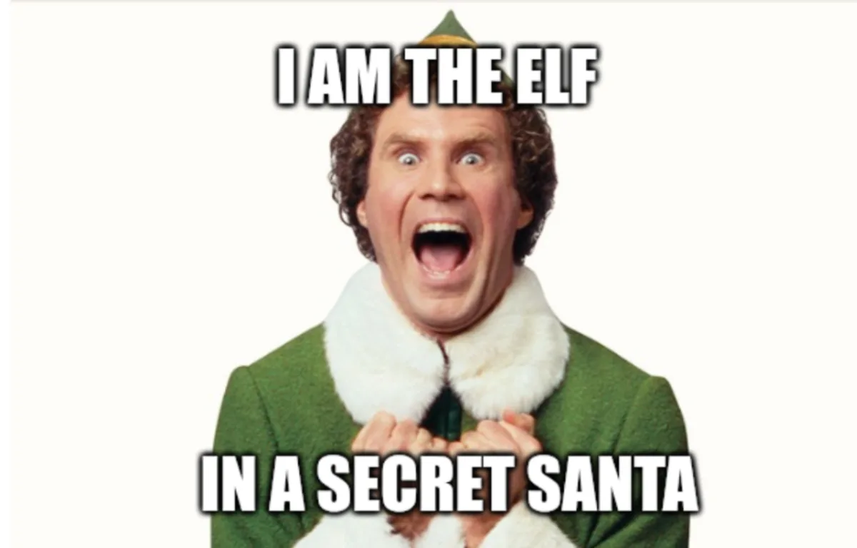 A man with curly brown hair, wearing a green elf costume with a white fur collar and a pointed green hat, has his mouth wide…
