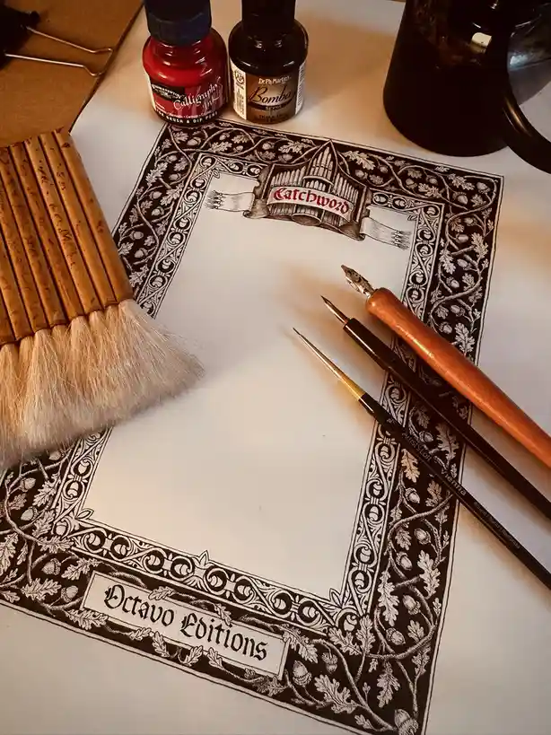 A close-up photo of a beautifully decorated calligraphy paper with an ornate border featuring acorns and vines, labeled…